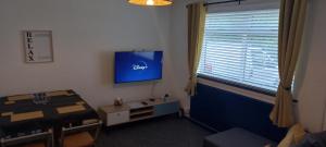 a room with a tv and a table and a window at 6-min Walk to New Cross Parking Long Stay Discounts in Fallings Park