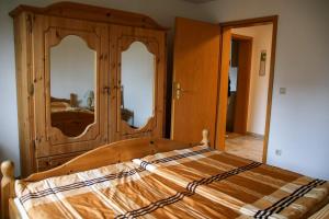 um quarto com uma cama de madeira e 2 espelhos em Ferienwohnung Erzgebirgsblick em Thermalbad Wiesenbad
