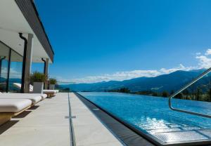 a swimming pool with mountains in the background at Hotel Ennstalerhof in Ramsau am Dachstein