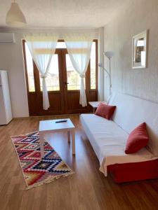 a living room with a white couch and a table at Sunny Home in Sandanski