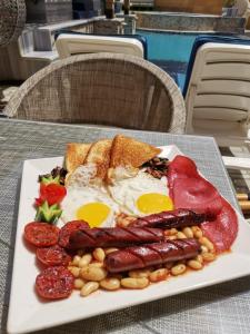 a plate of breakfast food with eggs sausage beans and toast at Geo Palace in Dahab