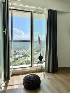a room with a large window with a vase on a table at MERDZ Spa & Fitness Sky Apartment in Skopje