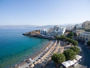 a view of a beach with umbrellas and the ocean at Oikies Luxury Apartments with private free parking area in Agios Nikolaos