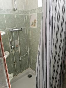 a shower with a black and white shower curtain in a bathroom at Maison proche circuit 24h du mans in Spay