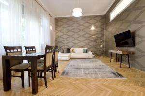sala de estar con mesa, sillas y sofá en Premium Apartment by Hi5 - Lendvay Palace en Budapest