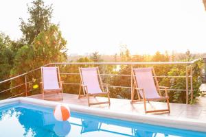 two deck chairs sitting next to a swimming pool at Casa Vista in Novi Sad