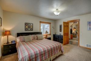 een slaapkamer met een bed met een gestreept dekbed bij 1 Particular Pine by Casago McCall - Donerightmanagement in McCall