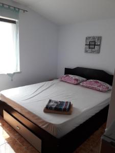 a bed with two pillows on it in a bedroom at Vila Roz in Mangalia