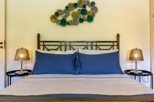 una camera da letto con un letto con cuscini blu e 2 lampade di La Dimora Dei Ciclopi ad Aci Castello