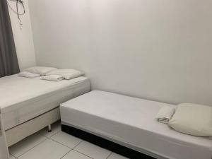 duas camas sentadas uma ao lado da outra num quarto em Condomínio Portal de Maragogi- Flats duplex super aconchegantes e confortáveis em Maragogi