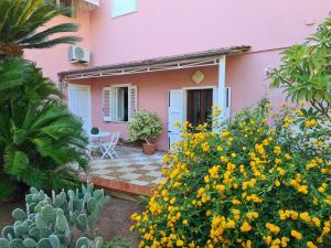 マルサラにあるCasa vacanze Villetta Frangipaneの黄色い花のピンクの家