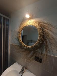 um espelho numa parede acima de um lavatório na casa de banho em B&B A San Pasquale em Racalmuto