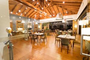 een restaurant met houten plafonds en tafels en stoelen bij Pliadon Gi Mountain Resort & Spa in Kato Trikala Korinthias