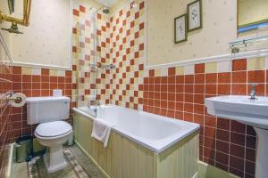 a bathroom with a toilet and a sink at The Portland Hotel in Lybster