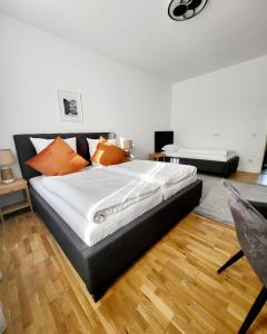 1 dormitorio con 1 cama grande con almohadas de color naranja en Marcel Apartments Leipzig, en Leipzig