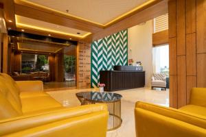 a lobby with yellow chairs and a coffee table at BayLeaf Inn in Port Blair