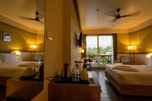 ein Hotelzimmer mit 2 Betten und einem Fenster in der Unterkunft BayLeaf Inn in Port Blair