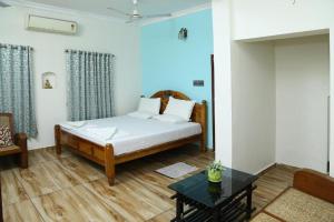 Schlafzimmer mit einem Bett und einem Tisch in der Unterkunft Jasmin Villa in Kochi