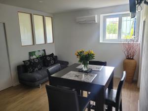 una sala de estar con una mesa y un sofá en Au Grand Chêne Jolie T3 à 5 min d'Albi, en Puygouzon-et-Montsalvy