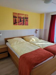 1 cama en un dormitorio con 2 pinturas en la pared en Ferienhaus Monarda, en Hahnenklee-Bockswiese