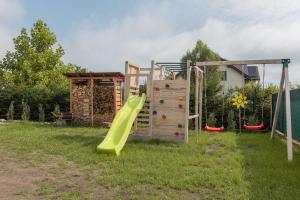 a playground with a slide and a climbing frame at Cyprysovnia in Gnieżdżewo