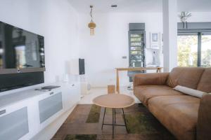 uma sala de estar com um sofá castanho e uma mesa em Villa Camilla, des vacances hors du temps em Saint-Pierre