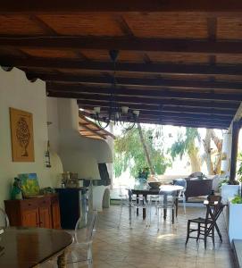 a living room with tables and chairs and a kitchen at La Villa Rossa in Santa Marina Salina