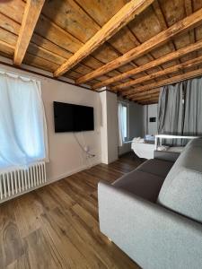 a living room with a couch and a flat screen tv at Borgovivo Il tuo Loft in centro città in Bergamo