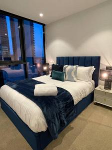 a bedroom with a large bed with a large window at Modern 3 Bedroom 2 Bathroom Apt Southbank in Melbourne