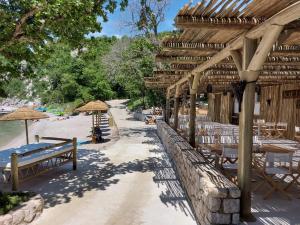 Holiday Homes Kačjak في دْرامالج: شاطئ به طاولات وكراسي ومظلات على شاطئ