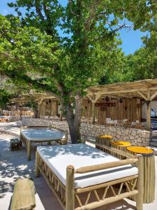 a patio with tables and benches and a tree at Holiday Homes Kačjak in Dramalj