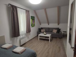 salon z łóżkiem i kanapą w obiekcie Kosbor Vendégház w mieście Monoszló