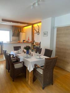 a dining room table with chairs and a white table cloth at Wildbach Chalet Turrach in Turracher Hohe