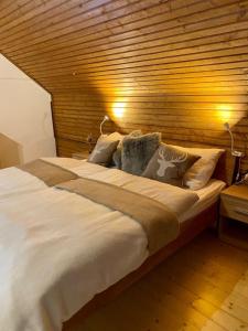 ein großes Bett in einem Schlafzimmer mit einer Holzwand in der Unterkunft Wildbach Chalet Turrach in Turracher Hohe