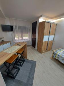 STIV Apartmani في Lukovo: مطبخ مع طاولة وسرير في غرفة