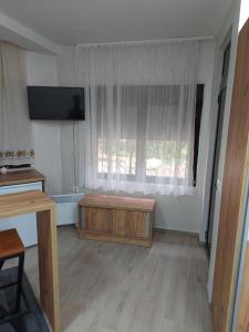 a living room with a television and a wooden table at STIV Apartmani in Lukovo
