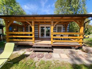a log cabin with a porch and a bench at kamp katra mobilna hiška EXCLUSIVE in Vinica