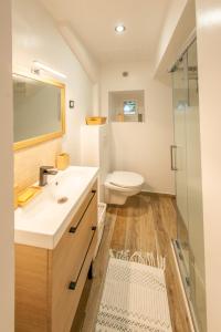 uma casa de banho com um lavatório branco e um WC. em Couvent des Cordelières supplément SPA em Vezins
