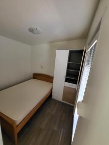 a small bedroom with a bed and a tv at kamp katra mobilna hiška EXCLUSIVE in Vinica
