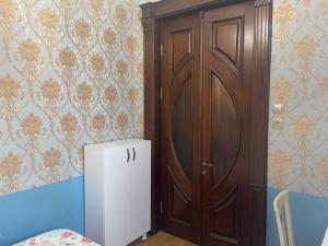 a room with a wooden door and a small refrigerator at hotel castle in Kutaisi +7 photos