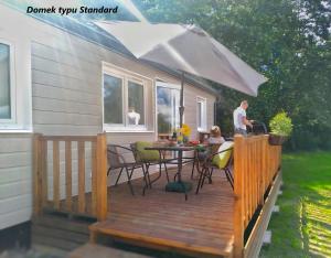 a deck with a table and chairs on a house at LUXURY CAMP - 150 m od Suntago Park in Grabce-Towarzystwo