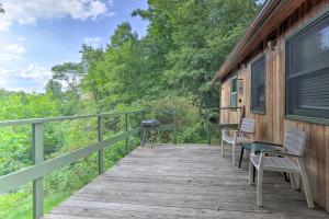 une terrasse en bois avec des chaises et une table. dans l'établissement Peaceful Spruce Pine Cabin on 8 Acres with 2 Decks!, à Spruce Pine