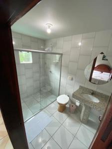 a bathroom with a shower and a toilet and a sink at Hotel Nosso Bosque in Rio do Sul