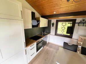 a small kitchen with white cabinets and a window at Sauerländer Henne-Lütt in Meschede