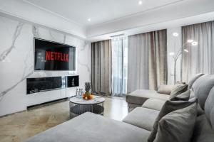a living room with a couch and a tv at Puerto Banús Beach Apartments in Marbella
