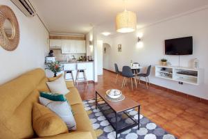 a living room and kitchen with a couch and a table at Paradise Gardens - Golf del Sur in San Miguel de Abona