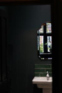 a bathroom with a sink and a mirror and a window at Sleep at 55 in Tarporley