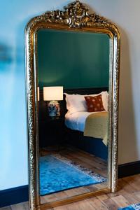 a large mirror with a bed in a room at Sleep at 55 in Tarporley