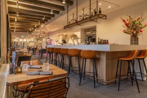 a restaurant with a bar with stools at Onderwijshotel De Rooi Pannen Breda in Breda