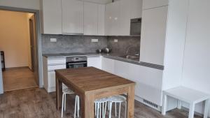 a kitchen with white cabinets and a wooden table at Lovely 1 bedroom apt in middle of city centre in Blansko